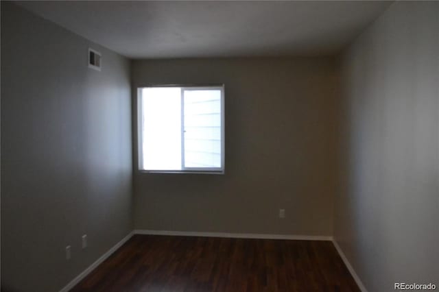 spare room with dark wood-type flooring