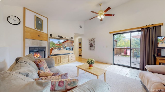 tiled living room featuring high vaulted ceiling, ceiling fan, and a tile fireplace