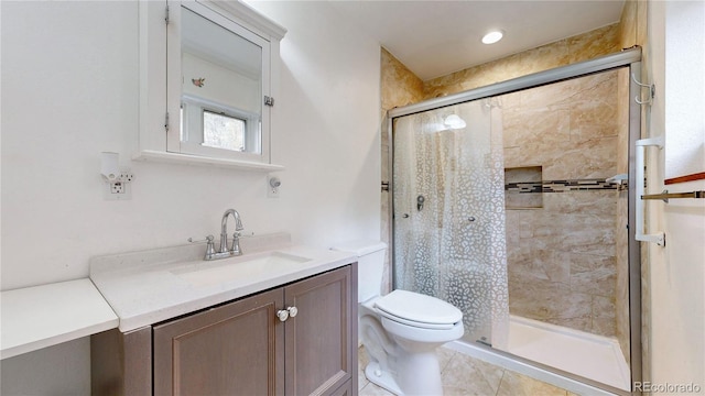 bathroom featuring vanity, tile patterned flooring, toilet, and a shower with shower door