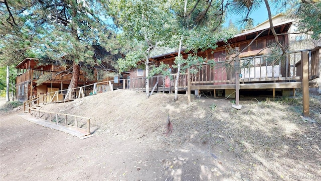 rear view of property featuring a wooden deck