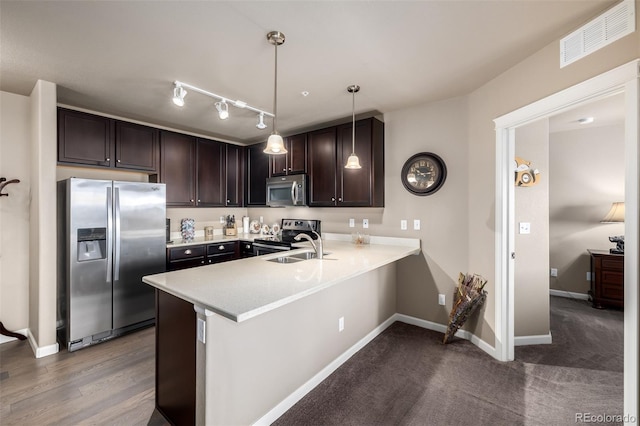 9258 Rockhurst St Unit 303, Highlands Ranch, CO 80129 - kitchen with appliances with stainless steel finishes, dark brown cabinets, light countertops, a peninsula, and baseboards