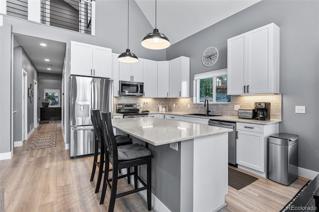 kitchen featuring white cabinets, sink, a kitchen island, and stainless steel appliances