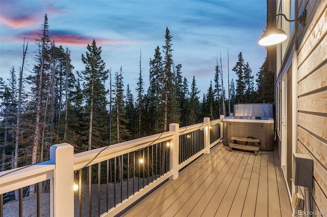 deck at dusk with a hot tub