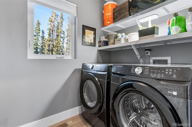 laundry area with hardwood / wood-style floors and washing machine and clothes dryer