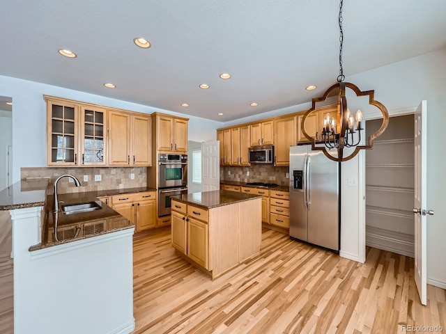 kitchen featuring light hardwood / wood-style flooring, appliances with stainless steel finishes, sink, and a center island