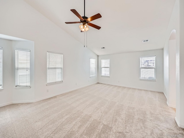 carpeted empty room with high vaulted ceiling and ceiling fan