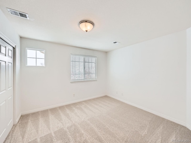 unfurnished room with light colored carpet