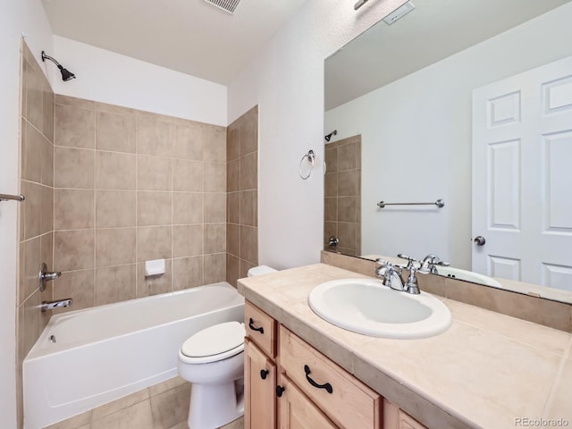 full bathroom featuring tiled shower / bath, tile patterned floors, toilet, and vanity