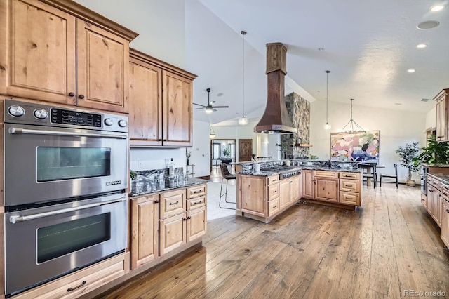 kitchen featuring dark wood-type flooring, ceiling fan, dark stone countertops, and stainless steel appliances