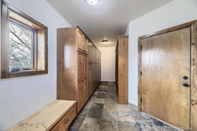 hall with stone tile floors