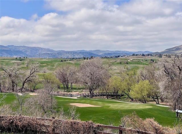 view of property's community featuring golf course view, a mountain view, and a lawn