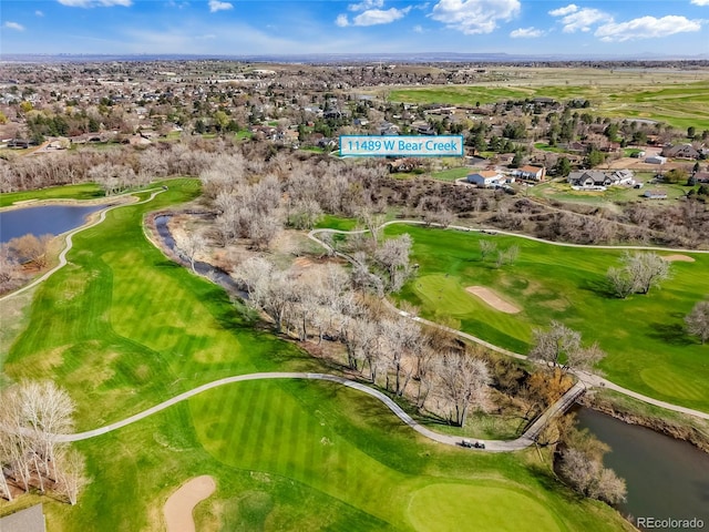 drone / aerial view featuring a water view, golf course view, and a residential view