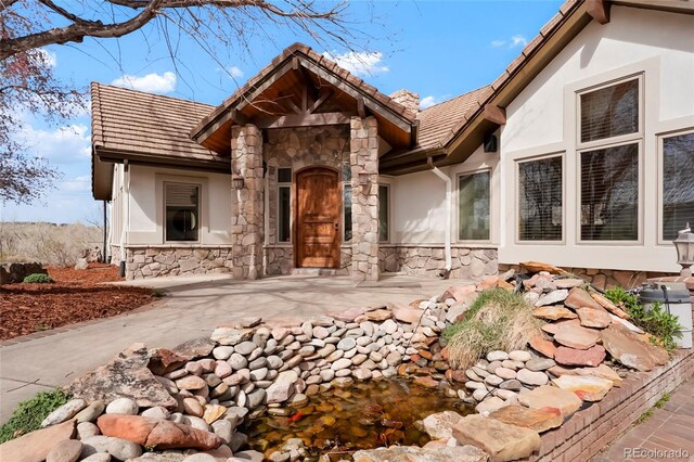 view of front of home featuring stucco siding and stone siding