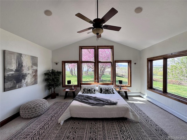 carpeted bedroom with baseboards, multiple windows, a baseboard heating unit, and vaulted ceiling