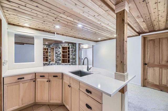 kitchen with light countertops, light brown cabinets, wooden ceiling, and a sink