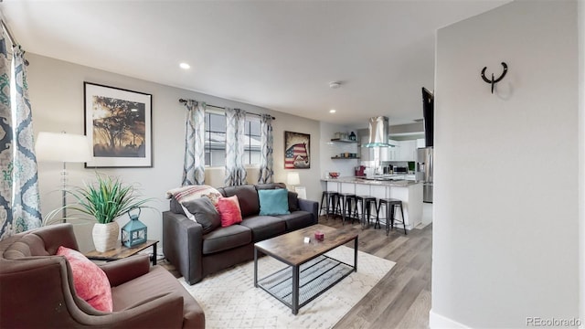 living area featuring light wood finished floors and recessed lighting