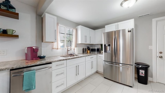 kitchen with white cabinets, open shelves, visible vents, a sink, and appliances with stainless steel finishes