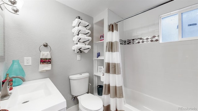 bathroom with a textured wall, toilet, shower / bath combo, and a sink