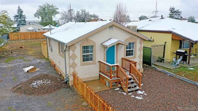 rear view of house featuring a fenced backyard, cooling unit, and stucco siding