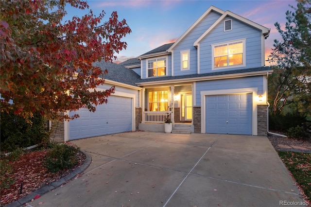 traditional home featuring driveway, stone siding, and roof with shingles