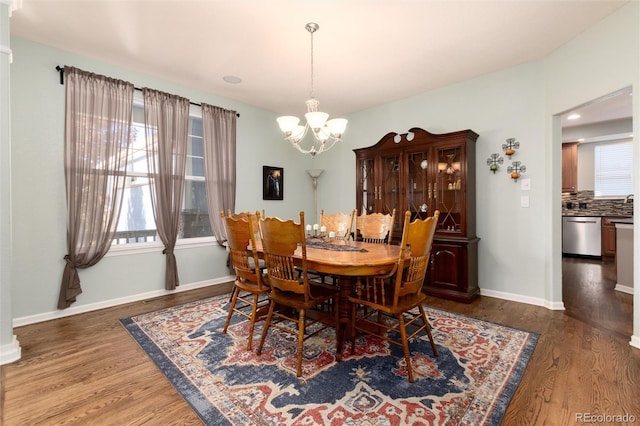 dining area featuring baseboards, a chandelier, and wood finished floors