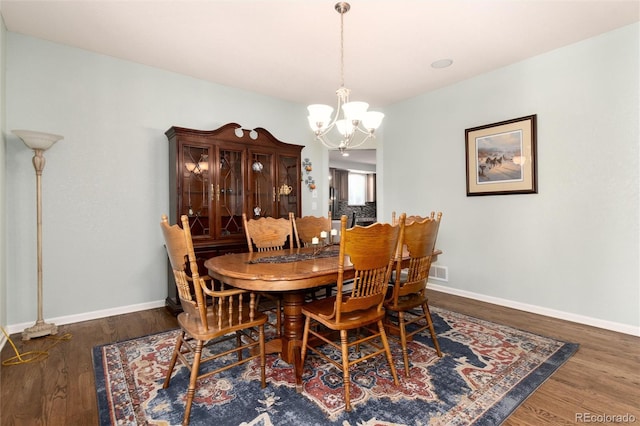 dining room with an inviting chandelier and dark hardwood / wood-style floors