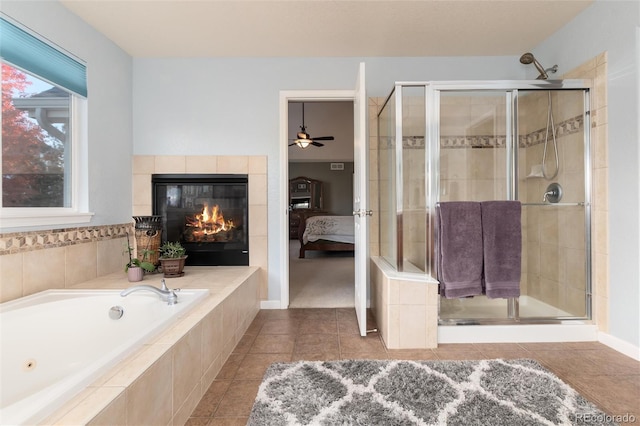 bathroom featuring a garden tub, tile patterned flooring, a stall shower, a tiled fireplace, and ensuite bath