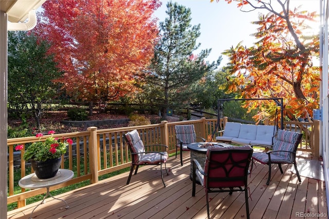 wooden terrace with an outdoor living space with a fire pit