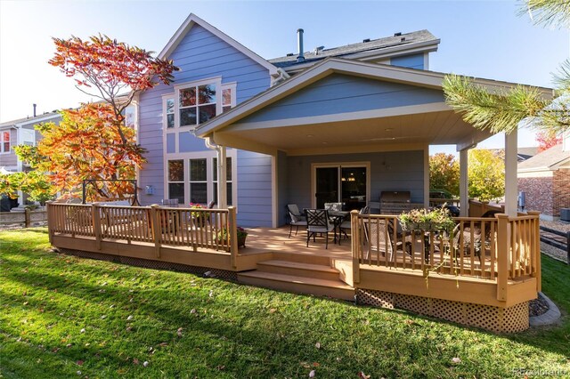 back of house with a lawn and a deck