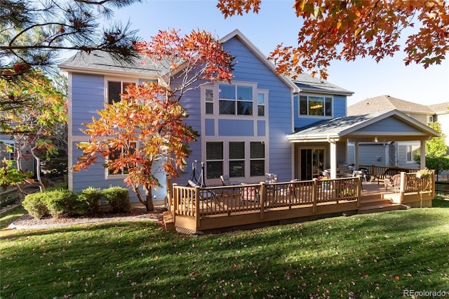 back of house with a deck and a lawn