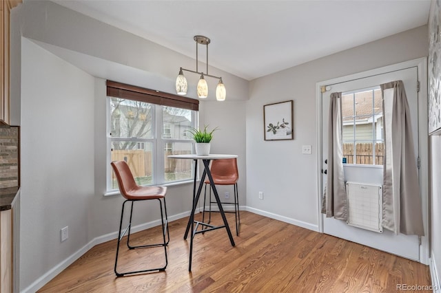 dining area with light wood-style flooring and baseboards