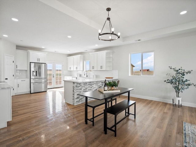 dining room with wood finished floors, a chandelier, baseboards, visible vents, and recessed lighting