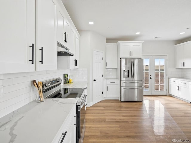 kitchen with decorative backsplash, under cabinet range hood, white cabinetry, and appliances with stainless steel finishes
