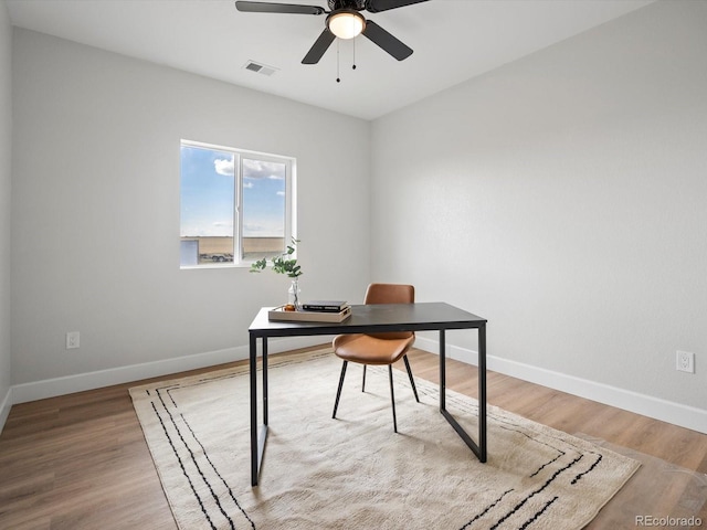 office area featuring visible vents, light wood-style flooring, baseboards, and ceiling fan