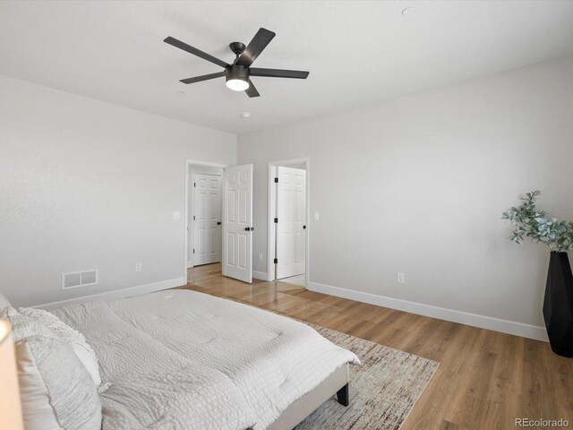 bedroom with baseboards, visible vents, and light wood-type flooring