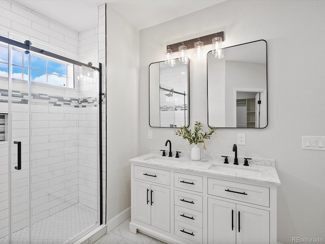 bathroom featuring baseboards, a sink, a shower stall, and double vanity