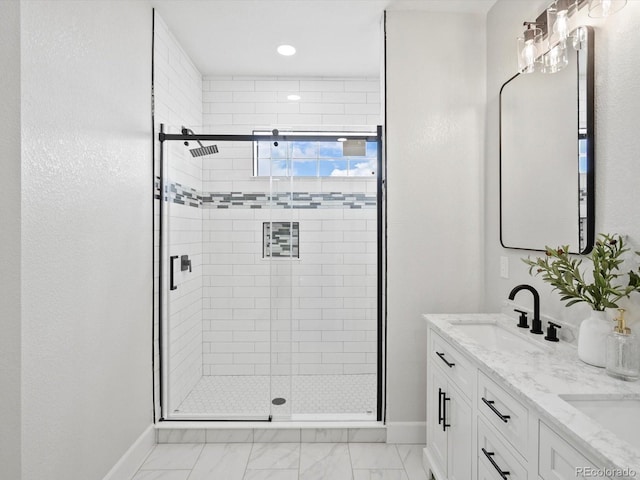 bathroom featuring a shower stall, baseboards, a sink, and marble finish floor