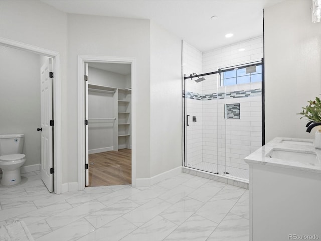 full bathroom with marble finish floor, a sink, a shower stall, and toilet