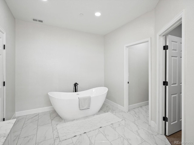 bathroom with marble finish floor, a soaking tub, visible vents, and recessed lighting