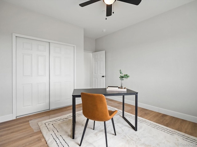 office space with baseboards, light wood-style floors, and ceiling fan