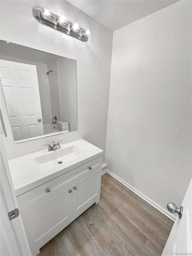 18306 E Gunnison Pl, Aurora, CO 80017 - bathroom with vanity, wood finished floors, and washtub / shower combination