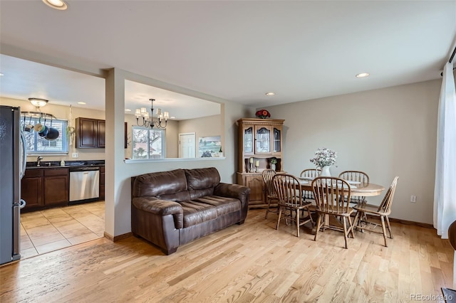 dining area featuring recessed lighting, baseboards, an inviting chandelier, and light wood-style flooring