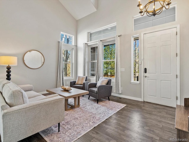 living room featuring high vaulted ceiling, dark hardwood / wood-style floors, and a chandelier