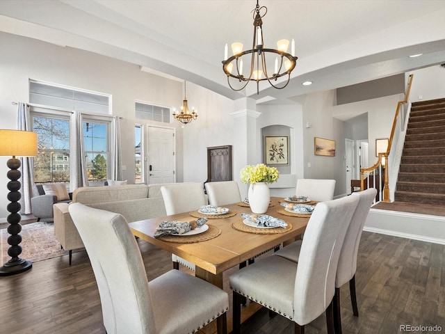 dining room with decorative columns, dark hardwood / wood-style floors, and an inviting chandelier