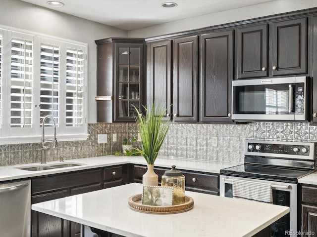 kitchen featuring stainless steel appliances, a healthy amount of sunlight, dark brown cabinets, and sink