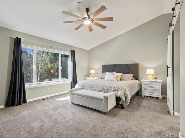 bedroom featuring lofted ceiling, a barn door, ceiling fan, and carpet