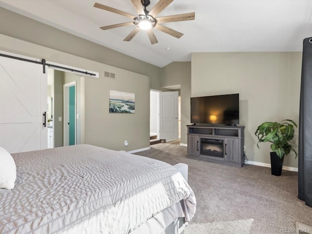 carpeted bedroom with ceiling fan, lofted ceiling, and a barn door