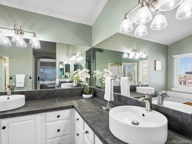 bathroom with vanity, vaulted ceiling, and walk in shower