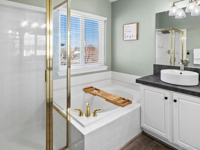 bathroom featuring hardwood / wood-style flooring, vanity, and shower with separate bathtub