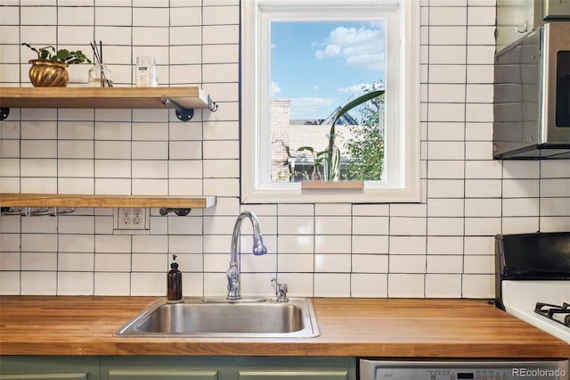 kitchen with decorative backsplash, stove, stainless steel dishwasher, sink, and green cabinets